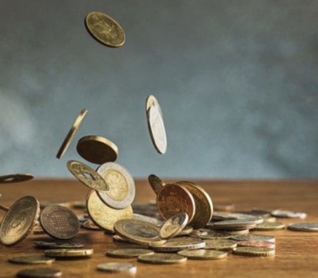 Coins falling onto a surface, symbolizing budget-friendly gifts